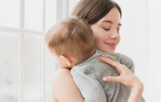 Young single mother lulling cradling her little small son daughter toddler infant newborn baby SVP - News - Is the Government living up to its own commitments on Childcare?
